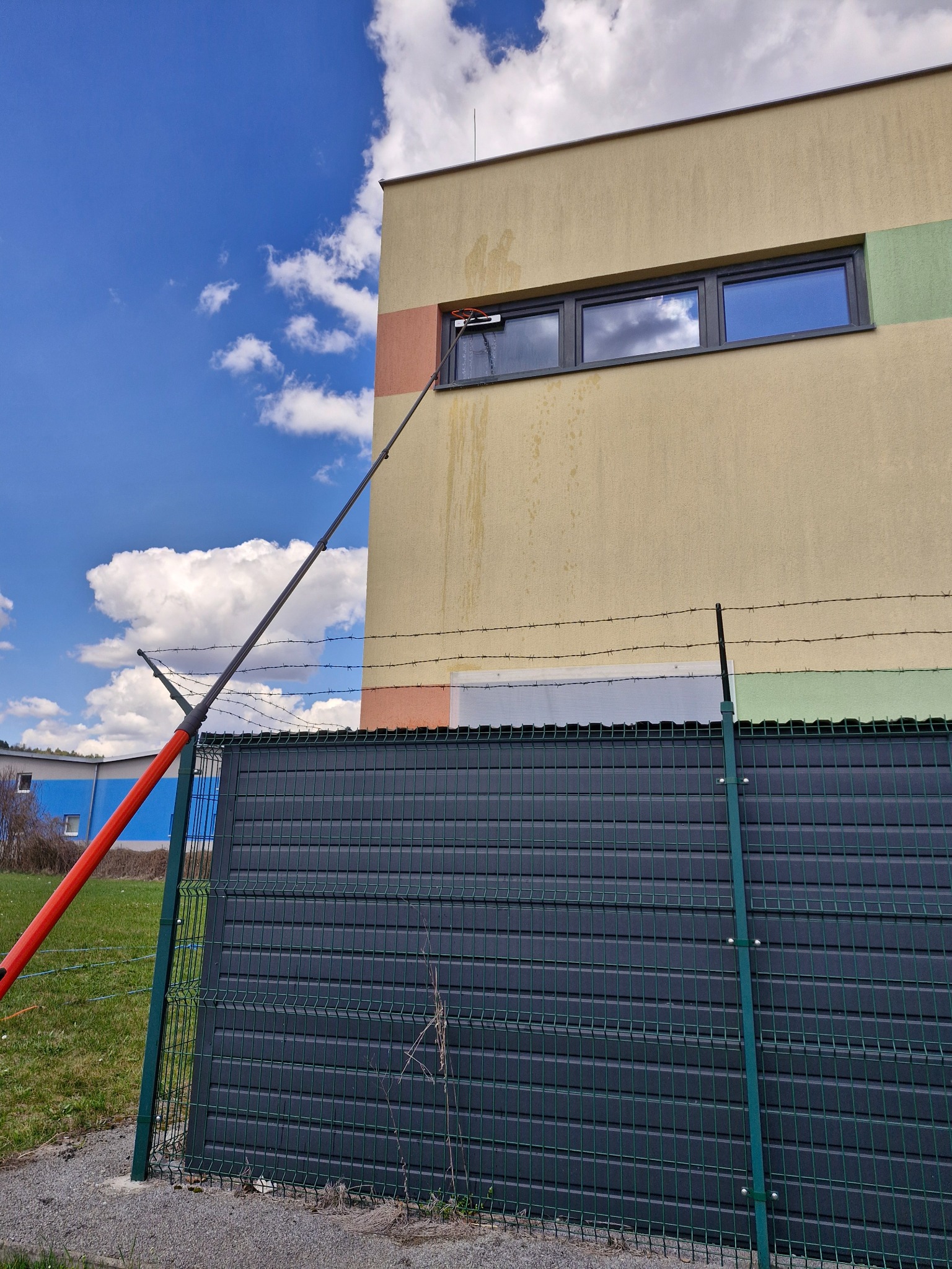 Kefa na teleskopickej tyči pri umývaní okien na vyššom podlaží