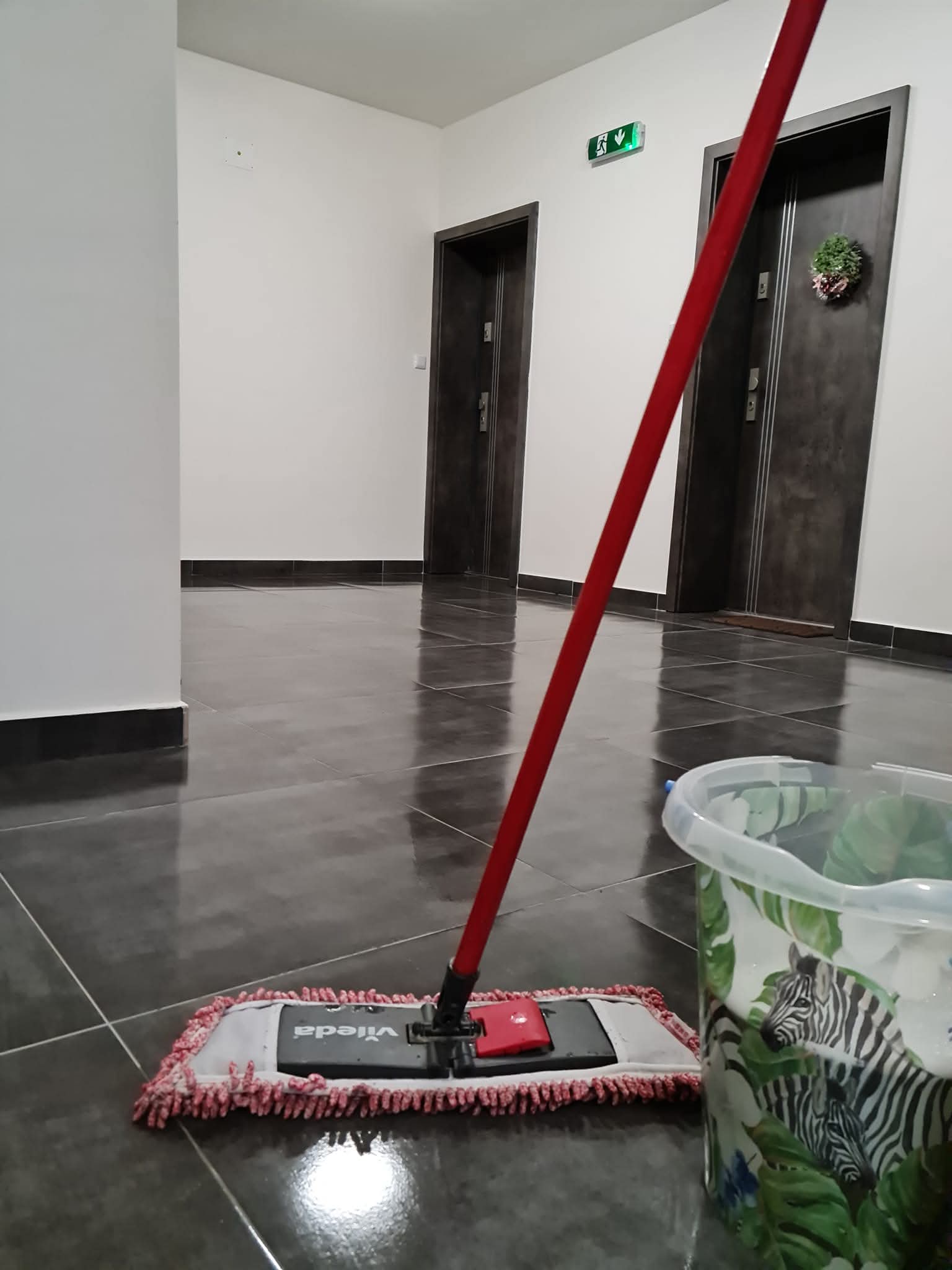 Mop a vedro pri umývaní podlahy v spoločných priestoroch bytového domu
